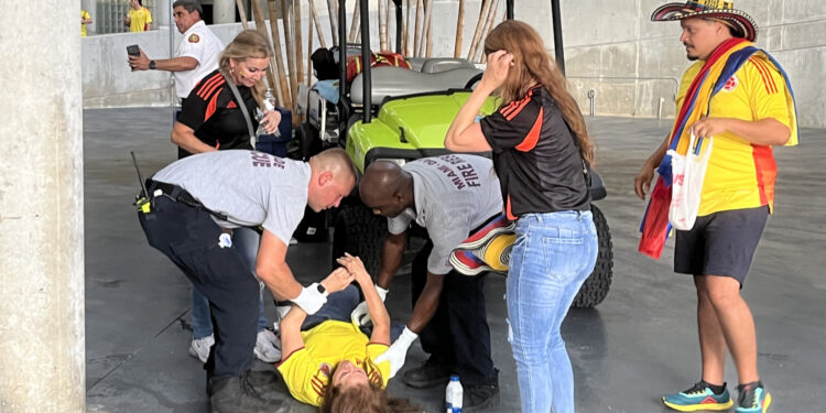 AME1862. MIAMI (ESTADOS UNIDOS), 14/07/2024.- Una mujer es atendida luego de sufrir un desmayo en el estadio Hard Rock previo al partido final entre Argentina y Colombia de la Copa América este domingo, en Miami (Estados Unidos). Una avalancha de decenas de aficionados con camisetas de la selección de Colombia y algunos de Argentina en una de las puertas de ingreso al estadio Hard Rock de Miami obligó a las autoridades a horas del comienzo de la final de la Copa América, a cerrar temporalmente el acceso de todo el escenario.EFE/ David Villafranca