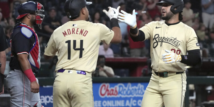 Arizona Diamondbacks' Eugenio Suárez celebrates with Gabriel Moreno (14) after hitting a two-run home run against the Washington Nationals in the first inning during a baseball game, Tuesday, July 30, 2024, in Phoenix. (AP Photo/Rick Scuteri)