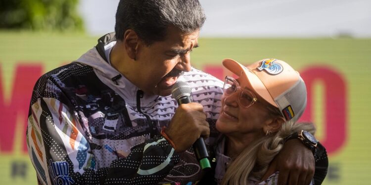 AMDEP3721. CARACAS (VENEZUELA), 16/07/2024.- El presidente de Venezuela y candidato reelección, Nicolás Maduro (i), abraza a la primera dama Cilia Flores en un acto de campaña este martes, en un sector popular en Caracas (Venezuela). Maduro invitó a sus seguidores a celebrar en el Palacio de Miraflores -sede del Gobierno-, en Caracas, su "triunfo" en las elecciones del 28 de julio, cuando competirá contra nueve opositores por el próximo sexenio en el poder. EFE/ Miguel Gutiérrez