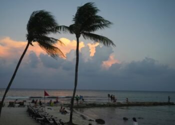 Gente en la playa mientras se pone el sol antes de la llegada del huracán Beryl en Playa del Carmen, México, el miércoles 3 de julio de 2024.