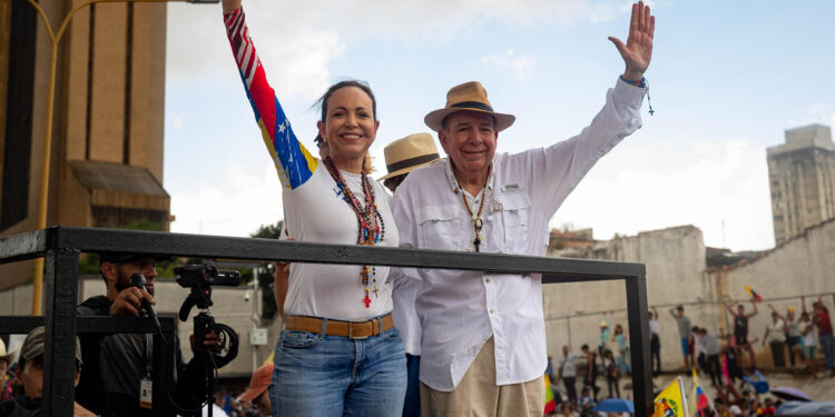 AME1670. VALENCIA (VENEZUELA), 13/07/2024.- La lider de la oposición, María Corina Machado (i) saluda a simpatizantes junto a el candidato presidencial, Edmundo González durante un acto de campaña este sábado en la ciudad de Valencia, estado de Carabobo (Venezuela). La líder opositora de Venezuela María Corina Machado sorteó este sábado "obstáculos" en su viaje hacia Valencia, estado Carabobo, al superar dos cierres de la autopista que conduce hacia esa ciudad, donde encabezará un acto de campaña junto al candidato presidencial Edmundo González Urrutia, de cara a las elecciones del 28 de julio. EFE/ Ronald Peña