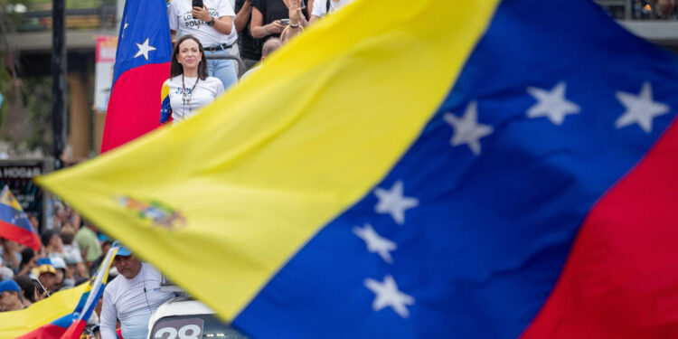 AME4910. CARACAS (VENEZUELA), 25/07/2024.- La líder opositora venezolana, María Corina Machado (i), participa en el cierre de campaña del candidato a la presidencia de Venezuela, Edmundo González Urrutia, este jueves, en Caracas (Venezuela). González Urrutia dijo que está convencido de su "triunfo" en los comicios del domingo, en los que competirá contra el mandatario Nicolás Maduro y otros ocho aspirantes. EFE/ Ronald Peña R.