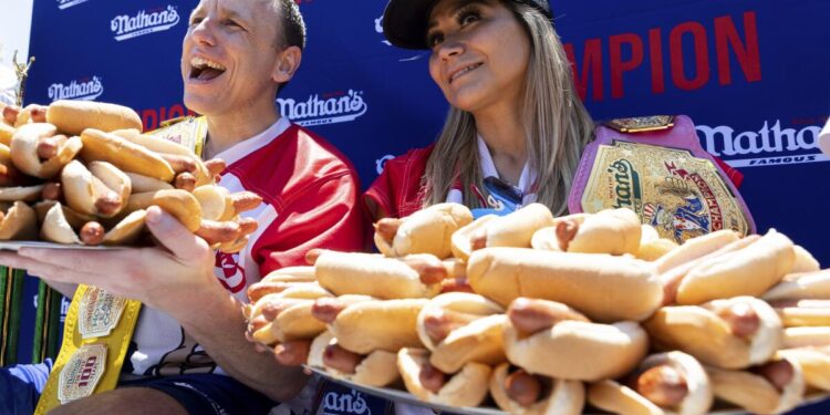 Joey Chestnut y Miki Sudo posan con 63 y 40 "hot dogs", respectivamente, tras ganar el concurso de perros calientes que organiza Nathan's Famous por el 4 de Julio en Coney Island, el lunes 4 de julio de 2022, en Nueva York. (AP Foto/Julia Nikhinson)