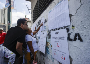 AME5617. CARACAS (VENEZUELA), 28/07/2024.- Ciudadanos venezolanos buscan su mesa de votación durante la jornada de elecciones presidenciales de Venezuela este domingo, en Caracas (Venezuela). El CNE informó este domingo que, sobre las 08.00 hora local (12.00 GMT), el 95 % de los 15.797 centros de votación ya estaban abiertos -dos horas más tarde la hora oficial fijada para la apertura- y computando los votos de personas que acudieron desde muy temprano a las urnas. EFE/ Henry Chirinos