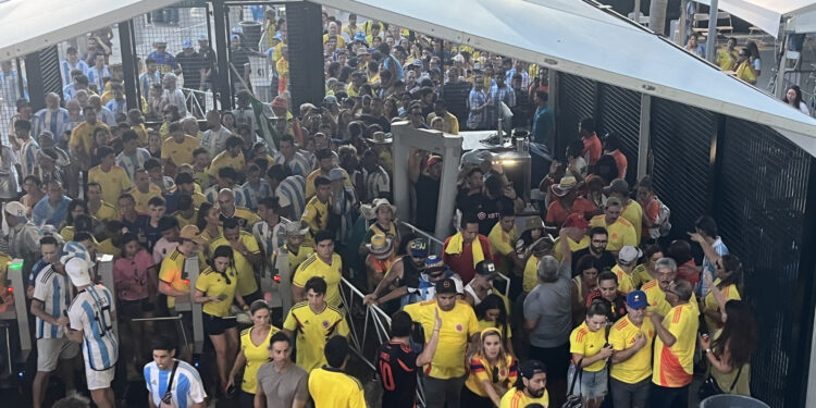 AME1862. MIAMI (ESTADOS UNIDOS), 14/07/2024.- Aficionados ingresan sin control al estadio Hard Rock este domingo previo a la final de la Copa América, en Miami (Estados Unidos). Poco después de instalarse el caos en varios sectores de ingreso al Hard Rock Stadium por fanáticos que ingresaron sin entradas, la policía retomó el control, pero luego los organizadores liberaron el ingreso de personas que arrastraron vallas a su paso. EFE/ David Villafranca