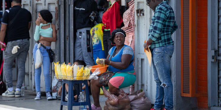 AME462. CARACAS (VENEZUELA), 09/07/2024.- Una mujer vende mango en el Bulevar de Sabana Grande, el 8 de julio de 2024, en Caracas (Venezuela). La inflación en Venezuela, que en junio cayó hasta el 1 %, se ha desacelerado a raíz de una política para estabilizar el precio del dólar -divisa usada en el país para cotizar bienes y servicios-, para lo que también se han "sacrificado" salarios y créditos bancarios, advierten expertos. EFE/ Ronald Peña