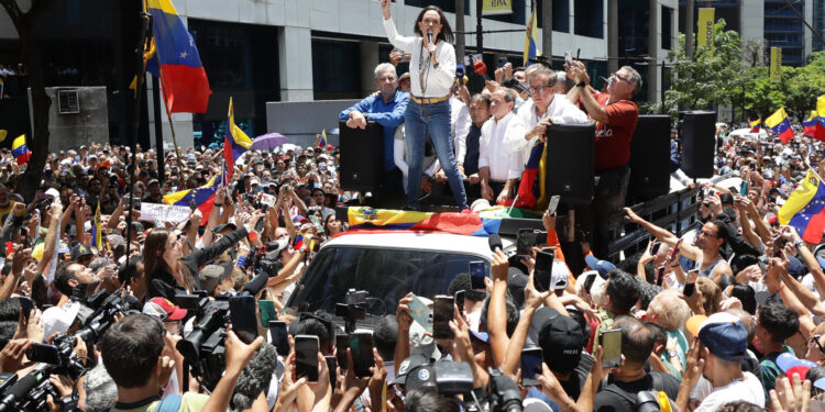 AME3983. CARACAS (VENEZUELA), 28/08/2024.- La líder opositora venezolana, María Corina Machado (c), pronuncia un discurso ante seguidores este miércoles, en una manifestación en Caracas (Venezuela). Machado aseguró que los militares del país "saben lo que tienen que hacer en esta hora", cuando se cumple un mes de las elecciones presidenciales, cuyo resultado oficial -que favoreció a Nicolás Maduro- la exdiputada señala de fraudulento, igual que buena parte de la comunidad internacional. EFE/ Ronald Peña