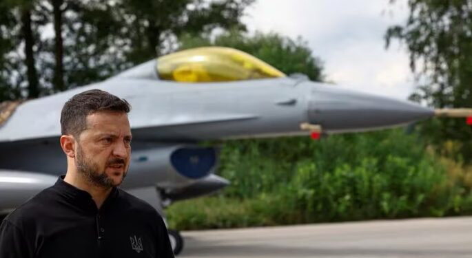 El Presidente de Ucrania, Volodimir Zelensky, se dirige a los medios de delante de un avión de combate F-16. (REUTERS/Valentyn Ogirenko)