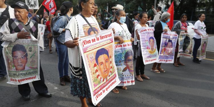 MEX6698. CIUDAD DE MÉXICO (MÉXICO), 26/08/2024.- Activistas, familiares y compañeros de los 43 estudiantes desaparecidos de la Escuela Normal "Isidro Burgos" de Ayotzinapa participan en una marcha, este lunes en la Ciudad de México (México). A un mes de que se cumpla una década de la desaparición de los 43 estudiantes normalistas de Ayotzinapa, familiares y activistas protestaron este lunes con un fuerte reclamo al presidente saliente Andrés Manuel López Obrador, a quien acusan de encubrir a los militares involucrados en el caso y de incumplir su promesa de resolver el caso. EFE/Mario Guzmán