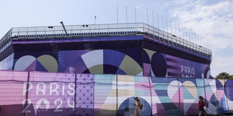 Paris (France), 12/08/2024.- Pedestrians walk past the Concorde ephemeral stadium for the Paris 2024 Olympic Games during its dismantling in Paris, France, 12 August 2024. After the closing ceremony of the Paris 2024 Olympic Games on 11 August 2024, some of the temporary stadiums are being dismantled or adjusted for the Paris 2024 Paralympic Games, which are scheduled to take place from 28 August to 08 September 2024. (Francia, Concordia) EFE/EPA/TERESA SUAREZ