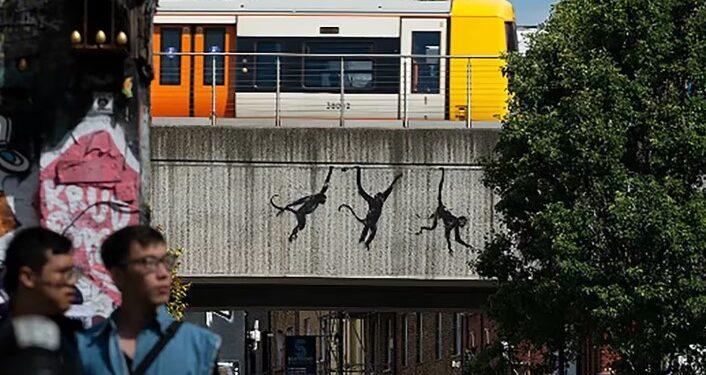 La última pintura de Banksy muestra a tres monos colgando de un puente.