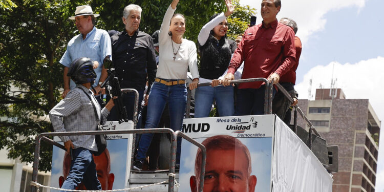 AME1188. CARACAS (VENEZUELA), 17/08/2024.- La líder de la oposición venezolana María Corina Machado (c) saluda en una movilización este sábado, en Caracas (Venezuela). Miles de opositores venezolanos se movilizan este sábado en las principales ciudades del país, en defensa de "la verdad" de las presidenciales del pasado 28 de julio, en las que la mayor coalición opositora asegura que ganó su abanderado, Edmundo González Urrutia, pese al resultado oficial que dio el triunfo al mandatario, Nicolás Maduro. EFE/ Miguel Gutiérrez