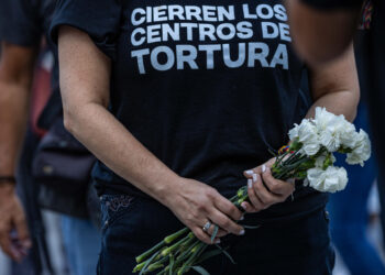 AME9122. CARACAS (VENEZUELA), 08/08/2024.- Una mujer sostiene flores durante la gran vigilia nacional por los presos políticos convocada por la oposición, este jueves en la plaza Los Palos Grandes, en Caracas (Venezuela). EFE/ Henry Chirinos