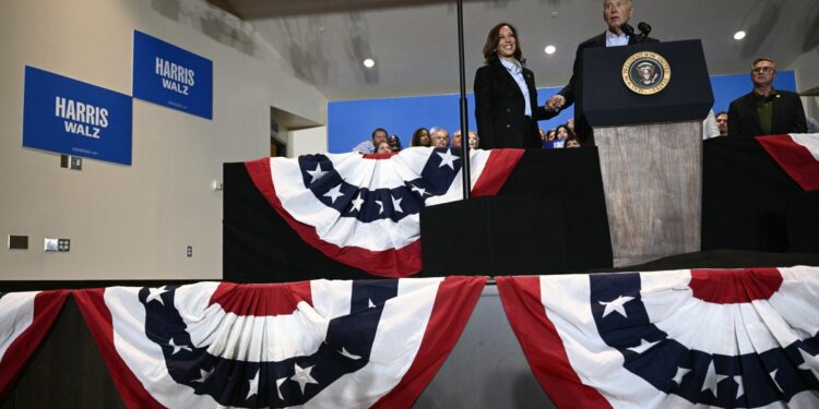 US Vice President and Democratic presidential candidate Kamala Harris (L) holds hands with US President Joe Biden as he speaks during a campaign rally at the International Brotherhood of Electrical Workers (IBEW) Local 5 in Pittsburgh, Pennsylvania, on September 2, 2024. (Photo by Brendan SMIALOWSKI / AFP)