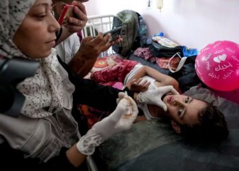 Una mujer administra una vacuna contra la polio a un niño, en Khan Younis (AP FotoAbdel Kareem Hana).