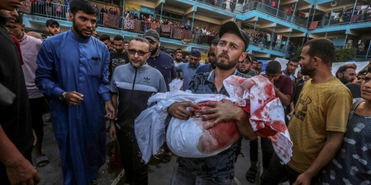 Nuseirat Camp (-), 11/09/2024.- An internally displaced Palestinian father carries the body of his son at a UNRWA-run school, a school-turned-shelter known as al-Jaouni, following an Israeli air strike in Al-Nuseirat refugee camp, central Gaza Strip, 11 September 2024. According to the Palestinian Ministry of Health in Gaza, at least 18 Palestinians have been killed and dozens injured following Israeli air strikes. The Israeli military stated that it conducted a 'precise strike' on militants operating inside a Hamas command and control center in the area of Nuseirat in central Gaza. More than 40,000 Palestinians and over 1,400 Israelis have been killed, according to the Palestinian Health Ministry and the Israel Defense Forces (IDF), since Hamas militants launched an attack against Israel from the Gaza Strip on 07 October 2023, and the Israeli operations in Gaza and the West Bank which followed it. EFE/EPA/MOHAMMED SABER -- ATTENTION EDITORS: GRAPHIC CONTENT