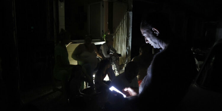 ACOMPAÑA CRÓNICA CUBA APAGONES AME8952. LA HABANA (CUBA), 19/10/2024.- Personas conversan durante un apagón este viernes, en La Habana, (Cuba). Cuando de verdad se sufre el apagón es de noche. Cuando las casas quedan totalmente a oscuras, las cocinas eléctricas no sirven para preparar la cena, los ventiladores inertes no espantan el calor caribeño y sólo las luces de un carro o un celular rompen el negro más rotundo. EFE/ Ernesto Mastrascusa