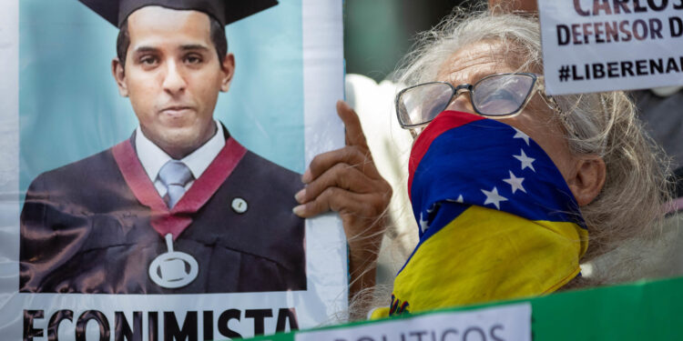 AME9454. CARACAS (VENEZUELA), 21/10/2024.- Una mujer sostiene un cartel durante una manifestación frente a la sede de la ONU, este lunes, en Caracas (Venezuela). Familiares de menores de edad detenidos en el contexto de las protestas desatadas tras las presidenciales del 28 de julio en Venezuela entregaron este lunes un documento a Unicef en Caracas, en el que piden a la agencia de la ONU que interceda para que sean liberados los 70 niños y adolescentes que -aseguran- permanecen encarcelados, así como para verificar en qué condiciones se encuentran. EFE/ Ronald Peña R.