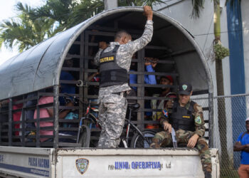 STO01.- HAINA (REPÚBLICA DOMINICANA), 07/10/2024.- Guardias vigilan a haitianos que fueron detenidos en redadas de autoridades migratorias, durante su traslado al centro de recepción de migrantes este lunes en Haina (República Dominicana). La decisión de la República Dominicana de deportar hasta a 10.000 indocumentados por semana mantiene en un estado de incertidumbre a los haitianos, que tratan de subsistir en la construcción, la agricultura o el comercio informal tras huir de su país, cuya situación económica y política se ha agravado en los últimos años por la violencia de las sangrientas bandas armadas. EFE/Orlando Barría