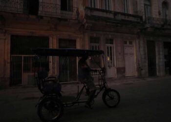 Fotografía de archivo de un bicitaxi que transita por una calle poco iluminada el 26 de marzo de 2024, en La Habana (Cuba). EFE/Yander Zamora