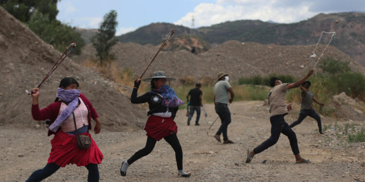 AME3509. PAROTANI (BOLIVIA), 31/10/2024.- Varias personas lanzan piedras utilizando una onda o 'Waraka' durante un entrenamiento, este jueves en Parotani (Bolivia). Los 'evistas', como se les conoce a los seguidores del expresidente de Bolivia Evo Morales (2006-2019), entrenan con tirapiedras para un eventual enfrentamiento con "militares o policías", según constató EFE este jueves en el principal bloqueo de carretera que algunos seguidores del líder oficialista mantienen en su defensa ante una posible orden de captura. EFE/ Luis Gandarillas