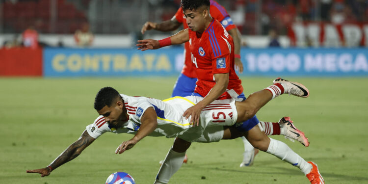 -FOTODELDÍA- AMDEP279. SANTIAGO (CHILE), 19/11/2024.- Fabián Hormazábal (arriba) de Chile disputa el balón con Miguel Navarro de Venezuela este martes, en un partido de las eliminatorias sudamericanas para el Mundial de 2026 entre Chile y Venezuela, en el estadio Nacional en Santiago (Chile). EFE/ Elvis González