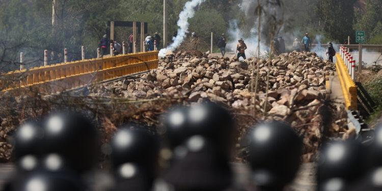 AME3727. PAROTANI (BOLIVIA), 01/11/2024.- Simpatizantes del expresidente de Bolivia, Evo Morales (2006-2019), se enfrentan con integrantes de la Policía Boliviana este viernes, en Parotani (Bolivia). Un gran contingente de policías y militares bolivianos desbloquean las carreteras tomadas por los seguidores del expresidente Evo Morales (2006-2019) desde hace 19 días, medida que ejercen en defensa de su líder ante una posible orden de captura en su contra por un caso de trata de personas y estupro. EFE/ Luis Gandarillas