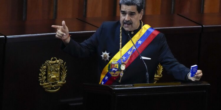 FILE - Venezuelan President Nicolas Maduro holds a small copy of his nation's constitution during ceremony marking the start of the judicial year at the Supreme Court in Caracas, Venezuela, Jan. 31, 2024. A secret memo obtained by The Associated Press details a covert operation by the U.S. Drug Enforcement Administration that sent undercover operatives into Venezuela to record and build drug-trafficking cases against the country’s leadership including Venezuelan President Nicolás Maduro. (AP Photo/Ariana Cubillos, File)