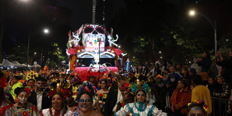 MEX3703. CIUDAD DE MÉXICO (MÉXICO), 27/10/2024.-Varias personas participan este domingo en el desfile de catrinas en Ciudad de México (México). Las principales calles de la capital Ciudad de México se llenaron la noche de este domingo de catrinas y catrines arropados de vestimentas prehispánicas, tradicionales por regiones y estados mexicanos y otros, entre carros alegóricos y calaveras de más de tres metros. EFE/Alex Cruz