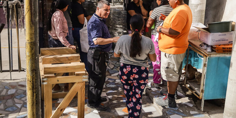 MEX4393. TIJUANA (MÉXICO), 04/11/2024.- El director del albergue Ágape Misión Mundial, Albert Rivera Colón (i) habla con migrantes el 3 de noviembre de 2024, en la ciudad de Tijuana (México). Los migrantes que se encuentran en albergues en la ciudad mexicana de Tijuana, fronteriza con Estados Unidos, mostraron este lunes preocupación e incertidumbre ante un posible triunfo del candidato republicano Donald Trump, al recordar las medidas que impulsó durante su pasada administración (2017-2021). EFE/Joebeth Terríquez