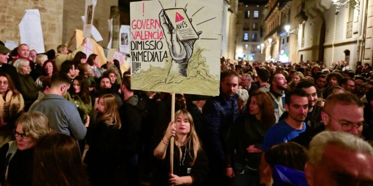 People carry banners during a demonstration to protest the regional government's response and call for the resignation of Valencia regional president Carlos Mazon, a month after devastating floods in Valencia, eastern Spain, on November 30, 2024. - The worst floods to hit Spain in decades on October 29 killed at least 230 people, covered towns in mud and debris, destroyed bridges, roads and rail lines and submerged cars, mainly in the eastern region of Valencia. (Photo by JOSE JORDAN / AFP)