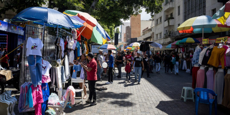 AME3731. CARACAS (VENEZUELA), 06/12/2024.- Fotografía del 29 de noviembre del 2024 de personas comprando en varios comercios en Caracas (Venezuela). Pantalones en 40 euros, cosméticos a partir de 10 euros y una promoción de dos camisetas por 20 ofrece una tienda de un país que no es europeo ni ha adoptado formalmente la divisa. Son los precios de un establecimiento en un centro comercial de Caracas, la capital de la Venezuela multimoneda. EFE/ Miguel Gutiérrez