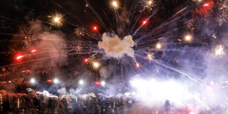 -FOTODELDÍA- EA2380. TBILISI (GEORGIA), 03/12/2024.- Simpatizantes de la oposición georgiana lanzan fuegos artificiales hacia la policía durante una protesta este martes frente al edificio del Parlamento en Tiflis (Georgia). Miles de activistas pro-UE continúan sus protestas en la capital georgiana contra la decisión del partido gobernante del país de suspender las conversaciones de adhesión con la Unión Europea (UE) hasta finales de 2028. EFE/EPA/DAVID MDZINARISHVILI