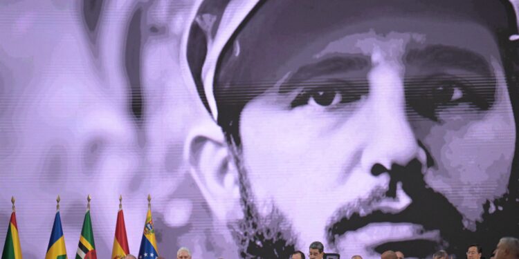 A photograph of Cuban late leader Fidel Castro is projected on a screen as Venezuela's President Nicolas Maduro speaks during the opening session of the XXIV ALBA-TCP Summit in Caracas on December 14, 2024. - The Bolivarian Alliance for the Peoples of Our America (ALBA) celebrates its 20th anniversary in a regional context where its influence is increasingly diminishing. The summit, originally planned in Havana where the founding document was signed, was moved to the Venezuelan capital at the peak of an economic crisis that is hitting Cuba. (Photo by JUAN BARRETO / AFP)