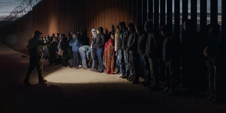 Migrantes junto al muro fronterizo en San Diego, California, en diciembre de 2023.
Qian Weizhong (Getty Images)