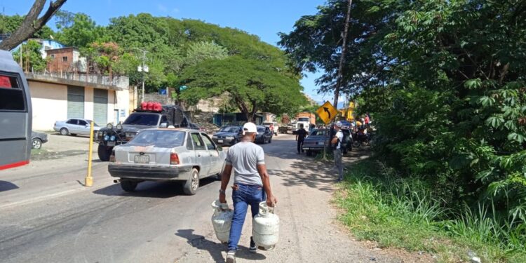 Los ciudadanos cargan sus bombonas para hacer la cola. Foto: Xiomara López | Radio Fe y Alegría Noticias.