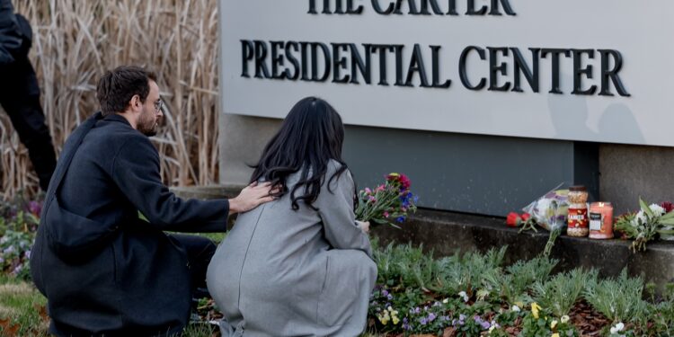 Atlanta (United States), 29/12/2024.- Mourners Nick Holte (L) and Esther Hyejin Chung (R) leave flowers in reaction to the death of former US President Jimmy Carter at the Carter Presidential Center Atlanta, Georgia, USA, 29 December 2024. Carter died on 29 December 2024 at his home in Plains, Georgia, The Carter Center confirmed. Carter was the 39th US President and a winner of the Nobel Peace Prize. He was also the longest-lived president in US history. EFE/EPA/ERIK S. LESSER