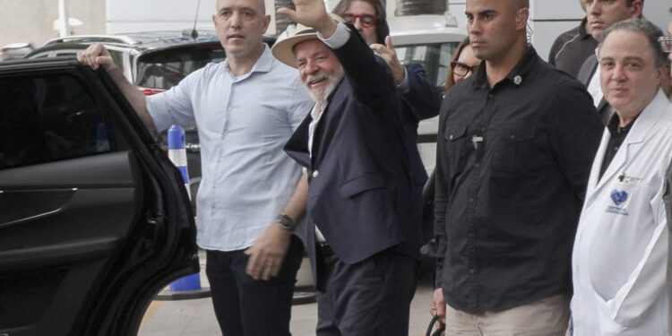 Frame grab from video footage by AFP TV shows Brazil's President Luiz Inacio Lula da Silva waving as he leaves the Syrian-Lebanese Hospital in Sao Paulo, Brazil, on December 15, 2024. - Brazilian President Luiz Inacio Lula da Silva was discharged Sunday from a Sao Paulo hospital following emergency surgery last week for an intracranial hemorrhage. (Photo by Carlos FABAL / AFP)