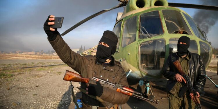 Aleppo (Syrian Arab Republic), 02/12/2024.- Armed men take selfies at the Nayrab military airport, in Aleppo, Syria, 02 December 2024. Syrian opposition forces, led by the Islamist militant group Hayat Tahrir al-Sham (HTS) launched an offensive on 27 November, taking large parts of Aleppo, Syria's second-largest city. The offensive triggered counterattacks by the Syrian regime forces as well as Russian and Syrian airstrikes on opposition-controlled areas. More than 400 people, including civilians and militants have been killed since 27 November, SOHR stated, while the United Nations Office for the Coordination of Humanitarian Affairs (OCHA) stated that over 20,000 people have been internally displaced within Aleppo and to other governorates. (Rusia, Siria) EFE/EPA/BILAL AL HAMMOUD