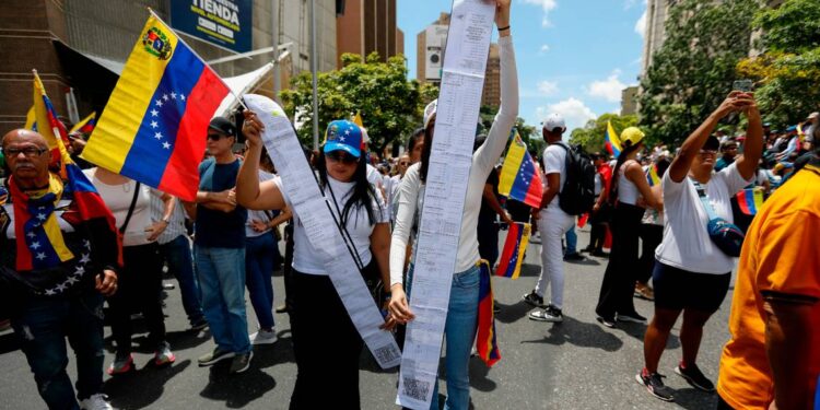 Venezolanos muestran copias de actas de votación para denunciar el presunto fraude electoral cometido por el gobierno de Nicolás Maduro, durante una protesta en Caracas el 17 de agosto de 2024. Jeampier Arguinzones dpa/picture-alliance/Sipa USA  Read more at: https://www.elnuevoherald.com/noticias/america-latina/venezuela-es/article297195699.html#storylink=cpy