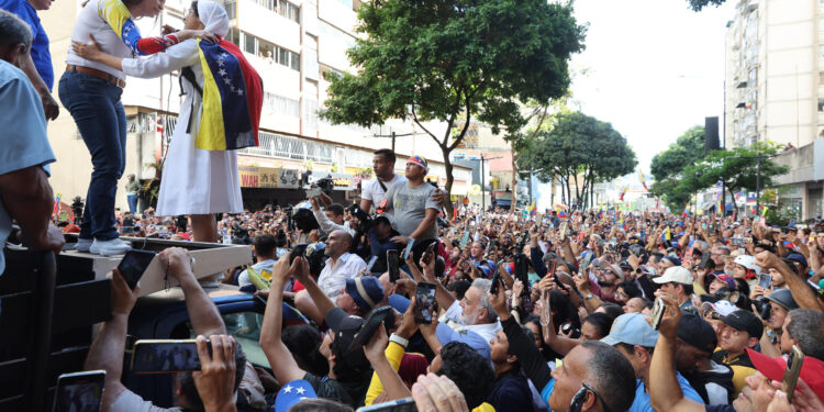 AME9799. CARACAS (VENEZUELA), 09/01/2025.- La líder antichavista María Corina Machado saluda a una de sus seguidoras este jueves, en una manifestación en Caracas (Venezuela). Machado expresó, cuando salió de la clandestinidad para participar en una protesta en Caracas, que Venezuela "superó el miedo" al estar en las calles para -aseguró- defender el reclamado triunfo de Edmundo González Urrutia en las elecciones del pasado julio, en las que Nicolás Maduro fue proclamado ganador por el organismo comicial. EFE/ Miguel Gutiérrez