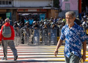 Riot police members stand guard as supporters of Venezuela's President Nicolas Maduro government take part in a demonstration on the eve of the presidential inauguration, in Caracas on January 9, 2025. Venezuela is on tenterhooks facing demonstrations called by both the opposition and government supporters a day before President Nicolas Maduro is due to be sworn in for a third consecutive term and despite multiple countries recognizing opposition rival Edmundo Gonzalez Urrutia as the legitimate president-elect following elections past July. (Photo by Betty Laura Zapata / AFP)