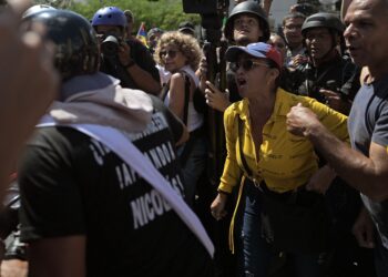 An opponet (C) of the Venezuelan government shouts at a supporter (L) of President Nicolas Maduro riding on a bike during a protest called by the opposition on the eve of the presidential inauguration, in Caracas on January 9, 2025. Venezuela is on tenterhooks facing demonstrations called by both the opposition and government supporters a day before President Nicolas Maduro is due to be sworn in for a third consecutive term and despite multiple countries recognizing opposition rival Edmundo Gonzalez Urrutia as the legitimate president-elect following elections past July. (Photo by JUAN BARRETO / AFP)