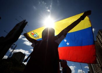 A demonstrator waves a Venezuelan flag during a protest called by the opposition on the eve of the presidential inauguration in Caracas on January 9, 2025. Venezuela is on tenterhooks facing demonstrations called by both the opposition and government supporters a day before President Nicolas Maduro is due to be sworn in for a third consecutive term and despite multiple countries recognizing opposition rival Edmundo Gonzalez Urrutia as the legitimate president-elect following elections past July. (Photo by Pedro MATTEY / AFP)