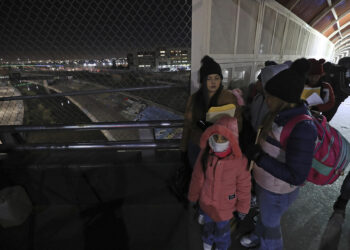 MEX352. CIUDAD JUÁREZ (MÉXICO), 20/01/2025.- Migrantes esperan en una fila en el puente Internacional Paso del Norte, este lunes en Ciudad Juárez (México). La cancelación de citas programadas para solicitudes de asilo ha dejado este lunes a cientos de familias en la frontera de México con Estados Unidos en una situación desesperada, ya que enfrentan la posibilidad de regresar a sus países de origen, donde muchos aseguran que su vida corre peligro. EFE/ Luis Torres