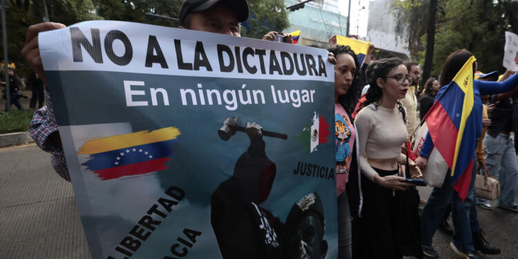 MEX9238. CIUDAD DE MÉXICO (MÉXICO), 09/01/2025.- Un venezolano opositor sostiene un cartel este jueves, en una manifestación frente a la embajada de Venezuela, en Ciudad de México (México). Un centenar de opositores venezolanos protestaron este jueves en la embajada de su país en México a un día de la investidura presidencial en Venezuela, que tanto el actual presidente, Nicolás Maduro, como el opositor Edmundo González Urrutia han prometido asumir. EFE/José Méndez