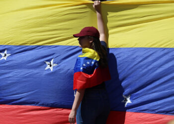 AME9799. CARACAS (VENEZUELA), 09/01/2025.- Una seguidora de la líder antichavista María Corina Machado sostiene la bandera de Venezuela este jueves, en una manifestación en Caracas (Venezuela). Machado expresó, cuando salió de la clandestinidad para participar en una protesta en Caracas, que Venezuela "superó el miedo" al estar en las calles para -aseguró- defender el reclamado triunfo de Edmundo González Urrutia en las elecciones del pasado julio, en las que Nicolás Maduro fue proclamado ganador por el organismo comicial. EFE/ Miguel Gutiérrez