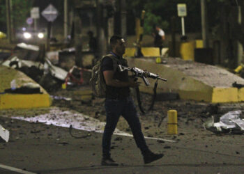 COL100. CÚCUTA (COLOMBIA), 20/02/2025.- Un policía inspecciona el peaje de Villa del Rosario destruido por explosivos este jueves en Cúcuta (Colombia). Una oleada terrorista sacudió en las últimas horas la frontera de Colombia con Venezuela donde desconocidos destruyeron el peaje ubicado en la autopista internacional que comunica a Cúcuta con San Antonio del Táchira, confirmaron las autoridades. EFE/ Mario Caicedo