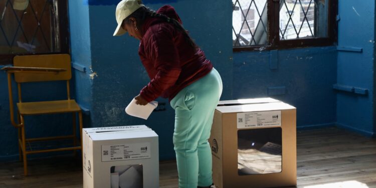 AME8737. QUITO (ECUADOR), 09/02/2025.- Una mujer introduce su voto en un puesto electoral en la Escuela 10 de Agosto durante las elecciones presidenciales y legislativas de Ecuador, este domingo en Quito (Ecuador). EFE/ Gianna Benalcazar