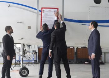 A seized sign is placed on a Venezuelan government airplane during a press conference where US Secretary of State Marco Rubio (R) announced its seizure at La Isabela International Airport in Santo Domingo, on February 6, 2025. The United States on Thursday seized a second aircraft belonging to the Venezuelan government in less than a year during a visit to the Dominican Republic by Secretary of State Marco Rubio, despite nascent diplomacy with leftist leader Nicolas Maduro. (Photo by Mark Schiefelbein / POOL / AFP)